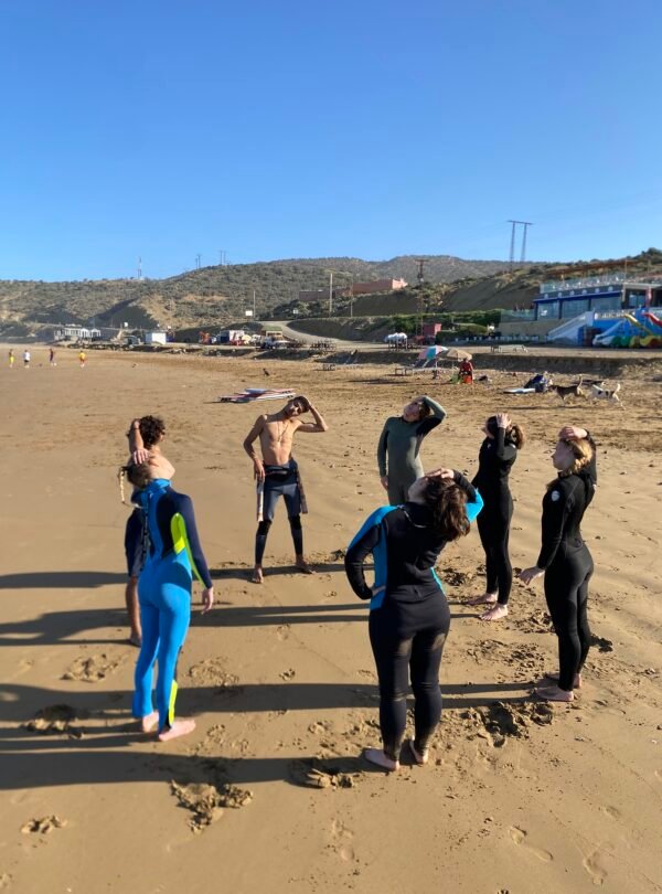 Group of surfers doing warm ups in Tamraght Morocco