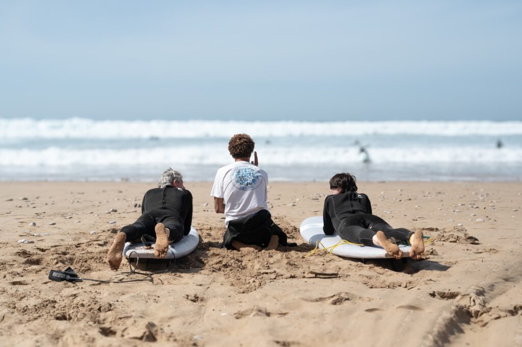 Family surfing together with Coach Samado at Paddle Out Morocco.